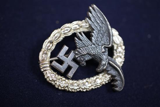 A collection of various German Third Reich cap badges, cloth badges and pins